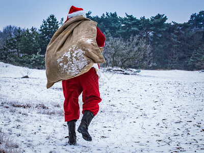 圣诞老人来到冬季森林带着一包礼图片