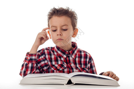 穿衬衫和一本大书思考的小男孩图片
