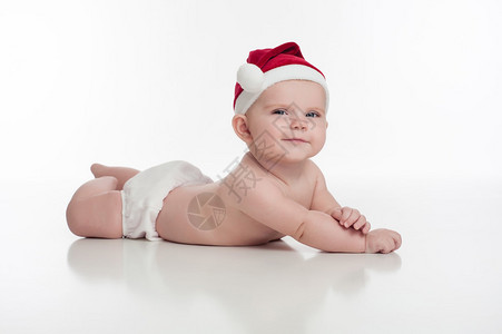 一个微笑的四个月大的女婴戴着圣诞老人的帽子和白色的尿布套背景图片