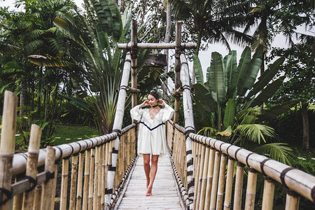 在乌布德巴厘岛的悬吊竹桥上行走的女孩图片