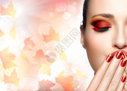 秋季化妆和美甲趋势秋季美容时尚女孩专业化妆和修指甲秋季背景下落叶图片