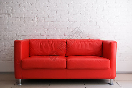 红色沙发和白色砖墙图片
