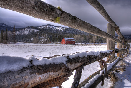 红色谷仓和栅栏营造出宁静的冬季环境图片