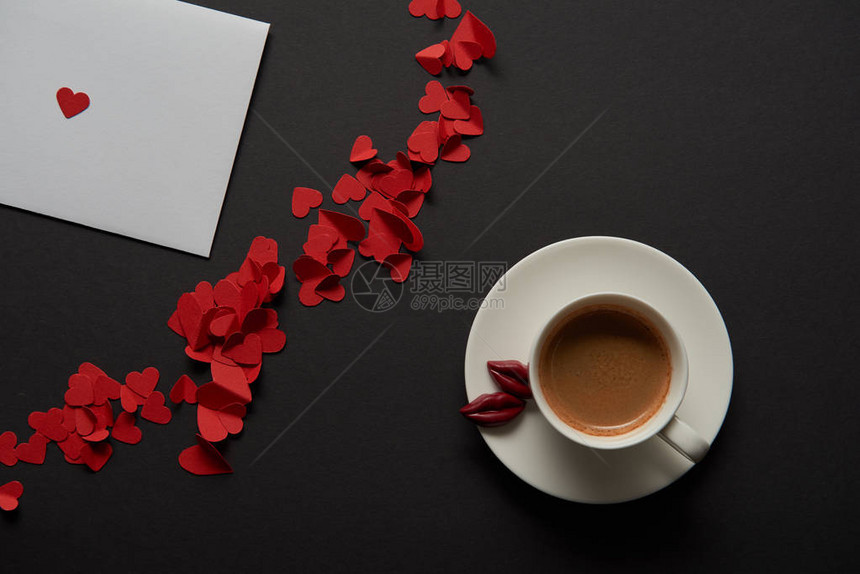 白贺卡上方有红纸切红心和咖啡杯的图片