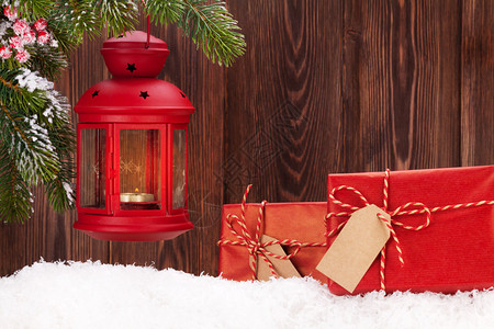圣诞蜡烛灯和雪中的礼品盒使用图片