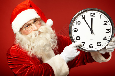 圣诞老人指向时钟的照片显示距离午图片