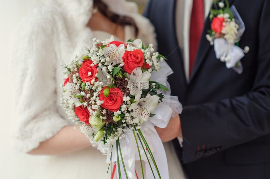 新娘捧花在新娘和新郎的手中近在咫尺图片