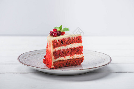 一块红色蛋糕装饰着花架在沙盘图片