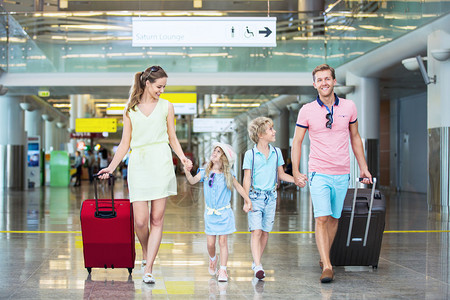 带着孩子在机场微笑的家庭图片