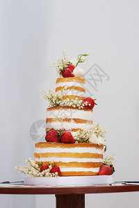 三层婚礼蛋糕桌上有草莓图片