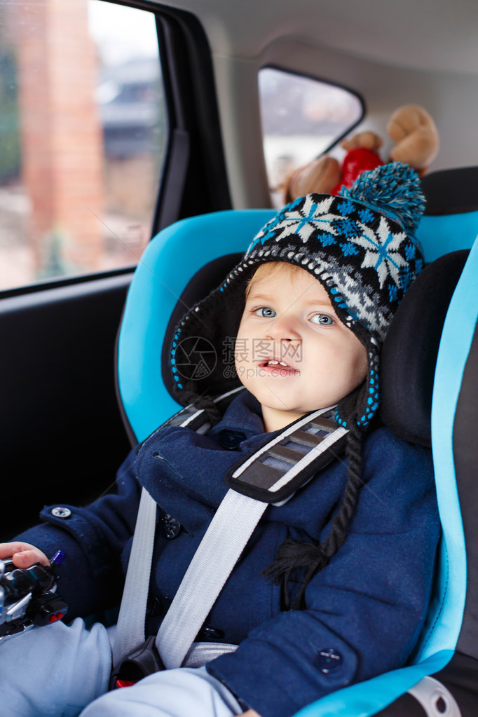 蓝眼睛的可爱蹒跚学步的男孩坐在汽车座椅上冬天衣服的孩子安全旅行儿童安图片