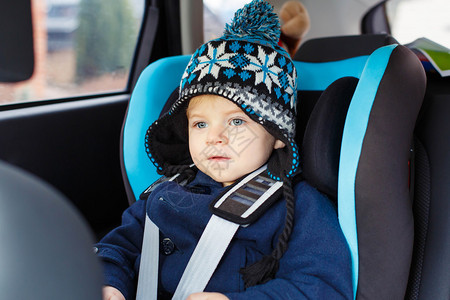 蓝眼睛的可爱蹒跚学步的男孩坐在汽车座椅上冬天衣服的孩子安全旅行儿童安图片