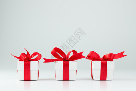 三个白色背景上的红丝带礼盒图片