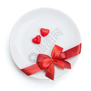 情人节情人节的心在红色弓盘上塑造了糖果图片