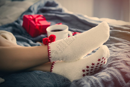 女脚和圣诞节茶杯与他人一起编织图片