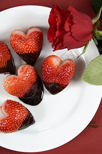 情人节快乐巧克力浸透心形草莓在白色的盘子上红色旧木本底图片