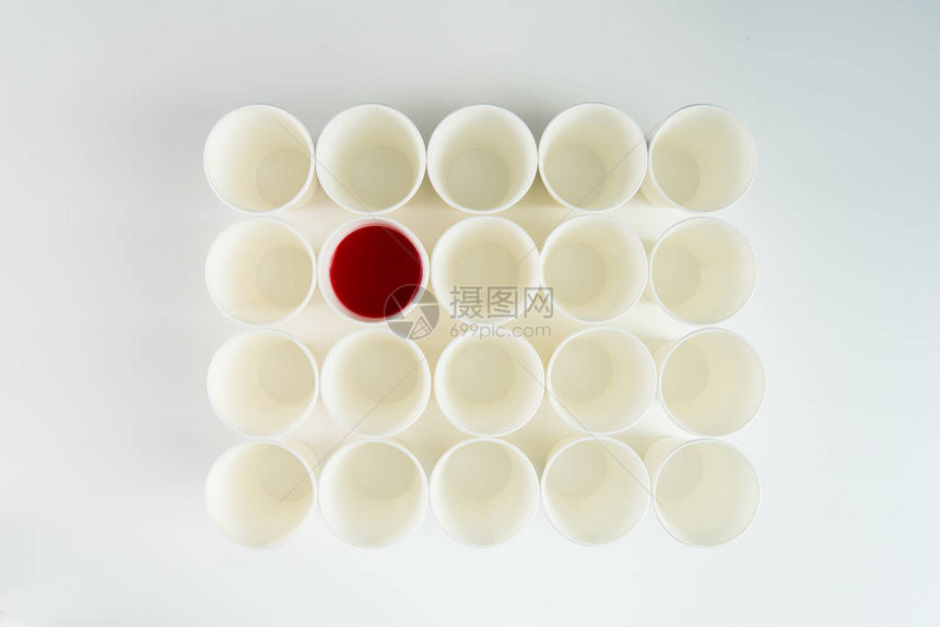 一组空塑料杯和一个带有红油图片