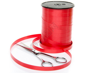 一卷闪亮的红丝带礼物用剪刀在白色上隔离图片