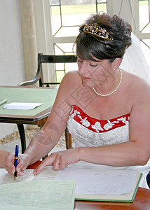 一位新娘在婚礼后在登记册上签名背景图片