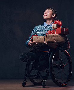 坐在轮椅上的正男子圣诞礼物在黑图片