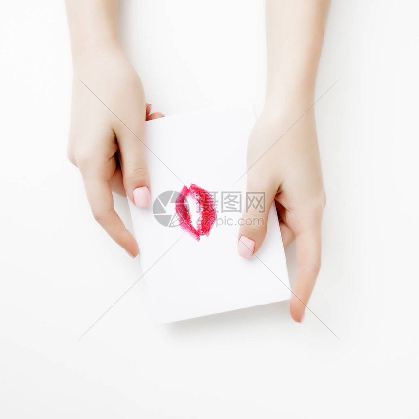 平躺顶视图在圣情人节写情书的女孩之手与红唇形图的手工明信片女人在明信片上亲吻2月14日的图片