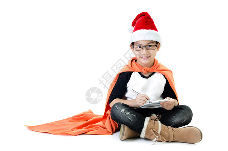 带着圣诞老人帽子的亚洲笑脸小男孩却在白背景上被孤图片