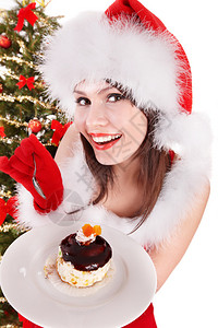 圣诞女孩穿着红圣塔帽和蛋糕在盘子背景图片