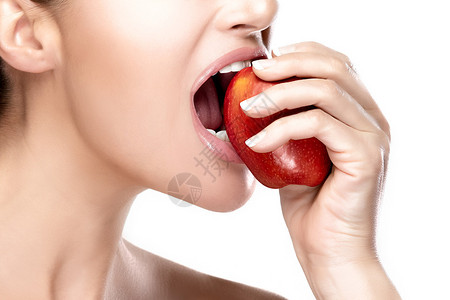 紧闭美丽健康的嘴唇咬着一个红苹果在白色背景上隔图片