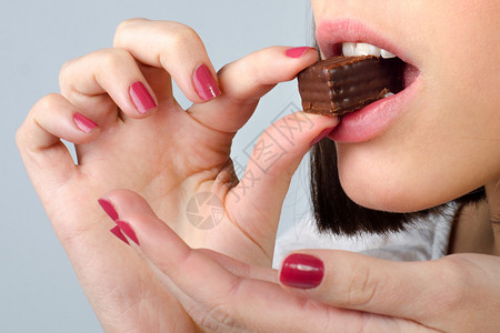 女孩吃巧克力饼干的详情孤立图片