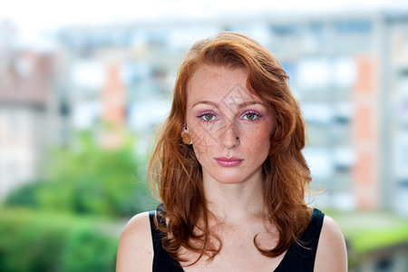 有吸引力的红头发雀斑的女人肖像外面背景图片