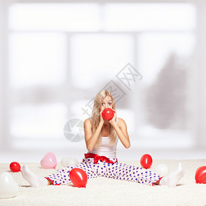 金发年轻女子坐在白色整层地毯上图片