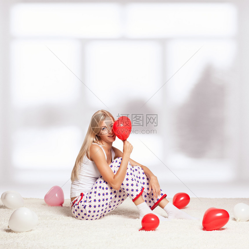 金发年轻女子坐在白色整层地毯上窗图片