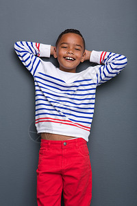 一个可爱的小黑男孩的肖像用双手在灰色背图片