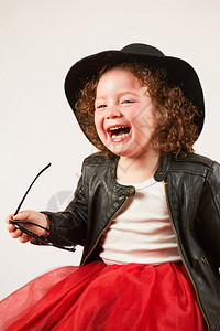 黑帽子坐着笑的小女孩图片