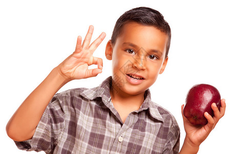 可爱的西班牙裔男孩与苹果和缩略图手势符号在图片