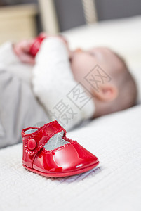 把红皮鞋放在床边和可爱的宝贝儿一起玩的背图片