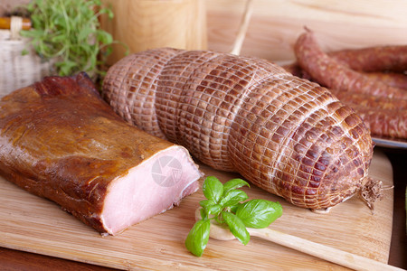 天然准备的慢速食物熏猪皮烤猪肩和火腿和环形香肠相似在木板上装图片