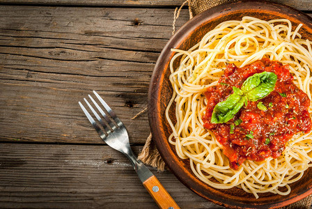 意大利菜午餐或晚餐意大利面糊和番茄马里纳拉酱以及黑木制桌边的烤肉复制图片