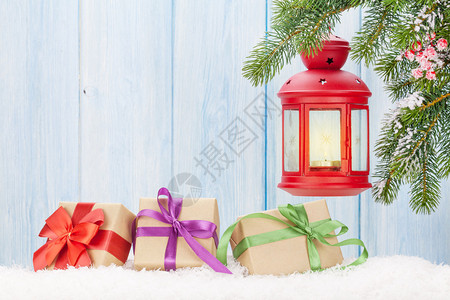 圣诞蜡烛灯礼品箱和雪中的fir树使用图片