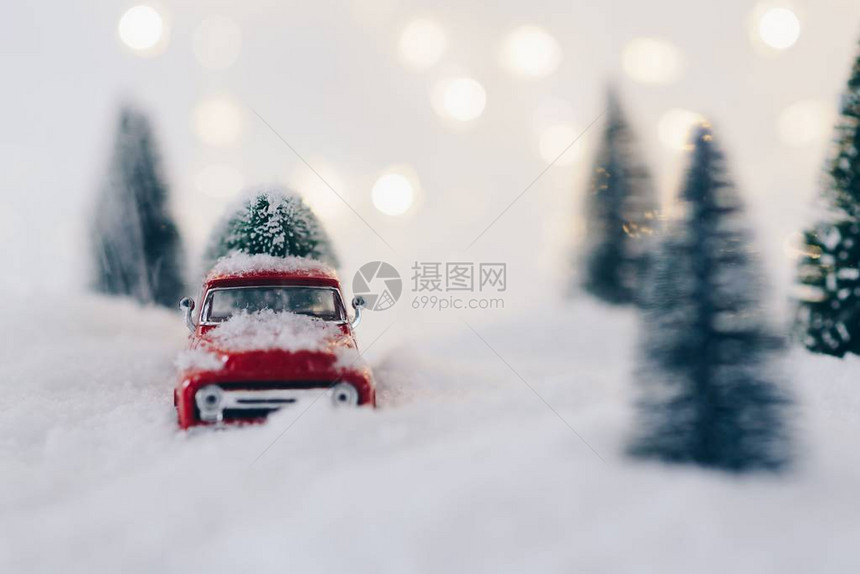 雪地里载着圣诞树的玩具皮卡车图片