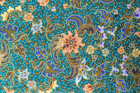 蓝色织物背景上的橙色花卉图案图片