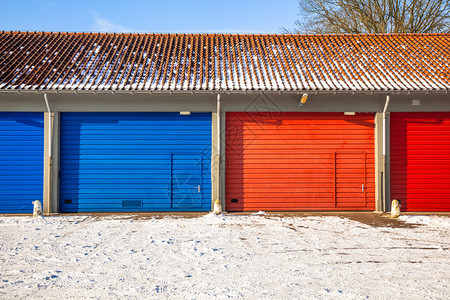 红火和蓝火旅车库门和Frost路在冬季雪日图片