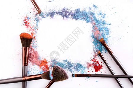 化妆刷框架与腮红和粉红色蓝色和珊瑚色调的眼影洒在白色上化妆和女图片