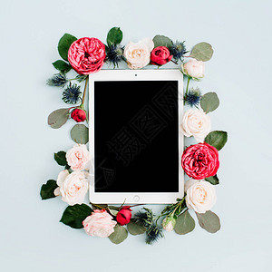平躺花卉框架与平板电脑红色和米色玫瑰花蕾淡蓝色背景顶图片