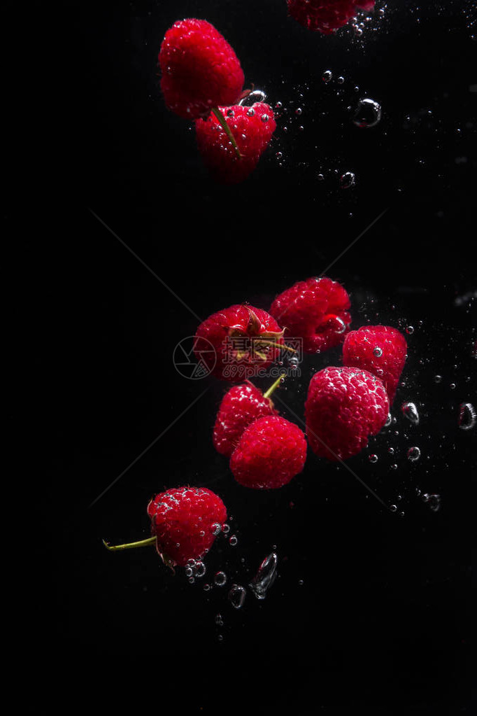 黑底的草莓在水中坠落高速闪电喷雾摄影新鲜的图片
