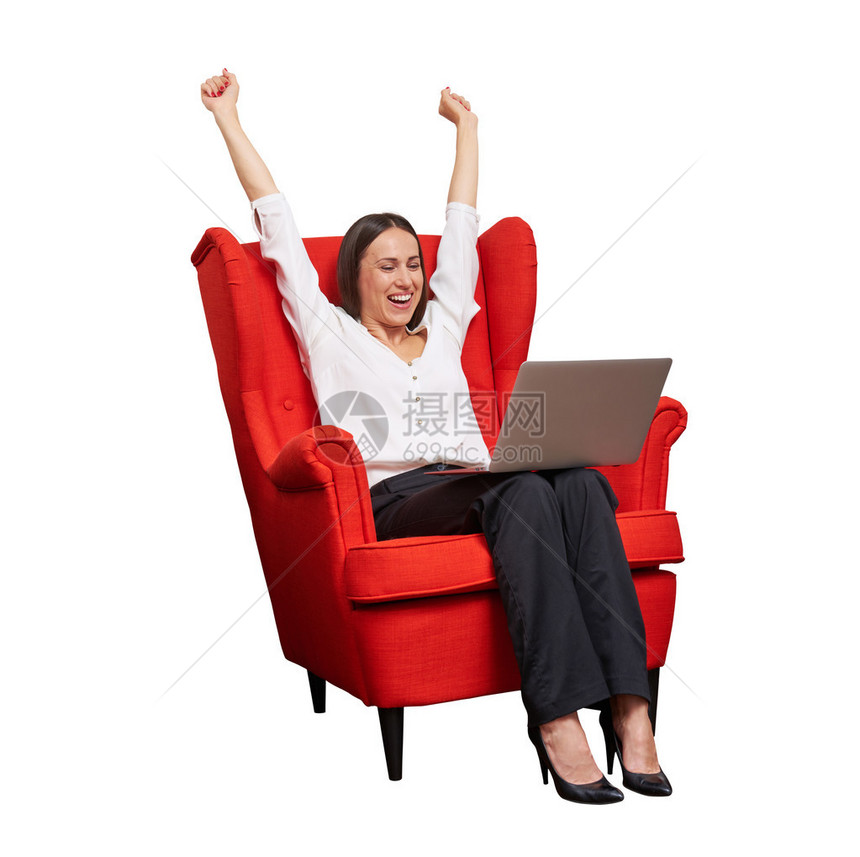 兴奋快乐的女商人举起双手坐在红色的椅子上图片