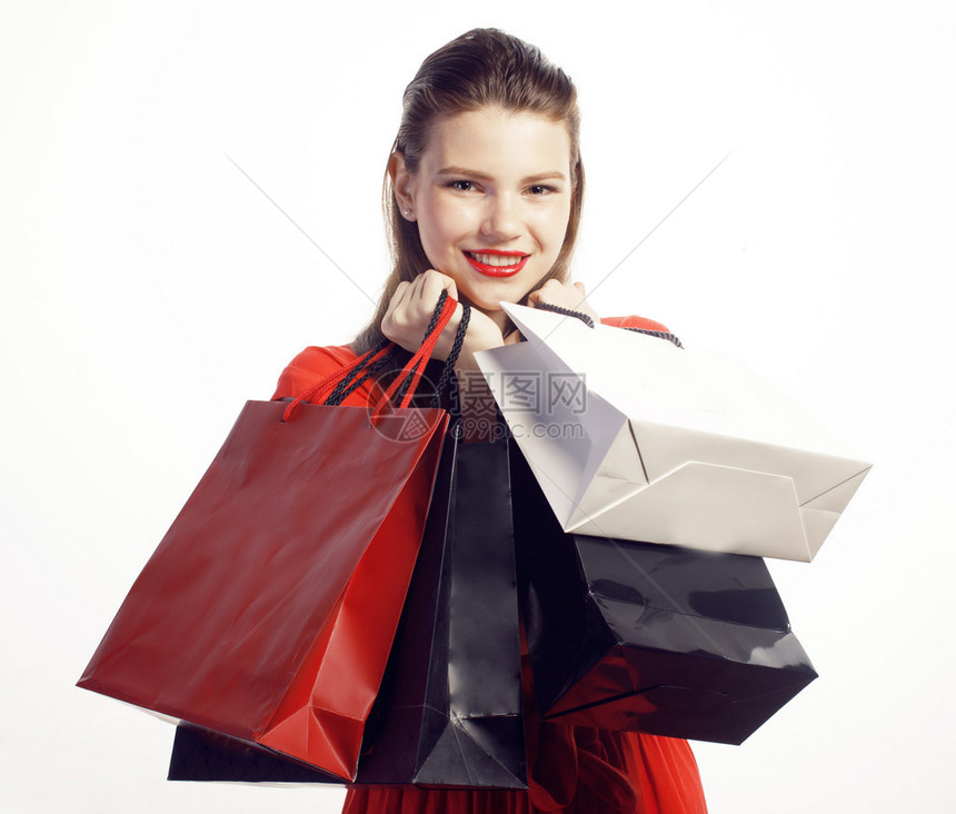 穿着红礼服的年轻美女在圣诞大卖上拿着袋子的漂亮女孩图片
