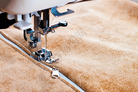在缝纫机上缝制一条白色拉链缝纫过程图片