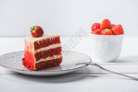 一块红色的蛋糕装饰着草莓在酱汁上图片