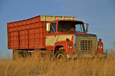 一辆老旧的红色谷物卡车停在长图片